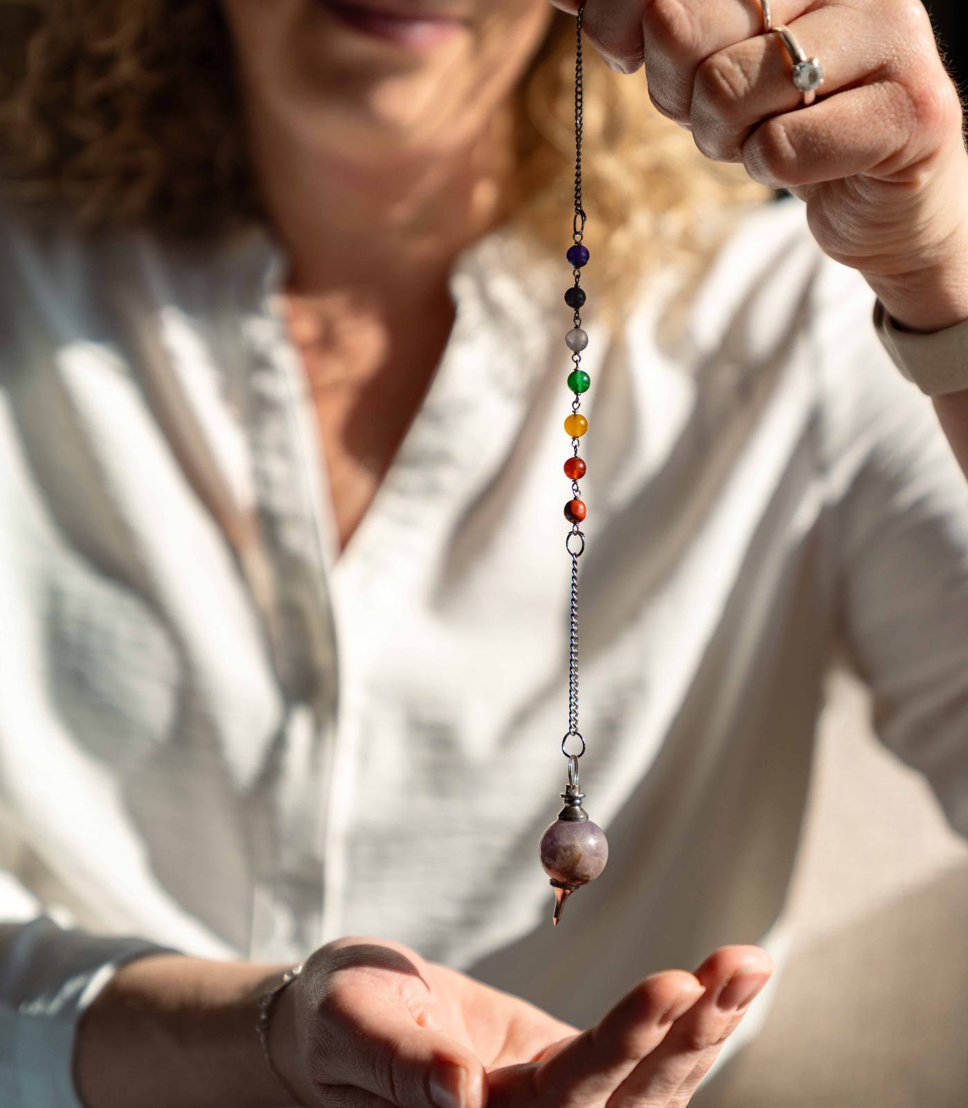 Anniek werkt met de pendel boven haar handpalm